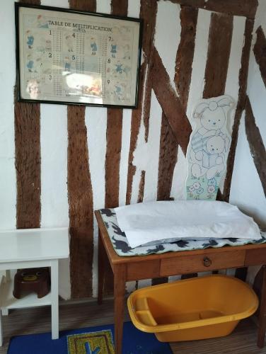 - un lit dans une chambre avec une table et un panneau dans l'établissement La petite chapelle, à Honfleur