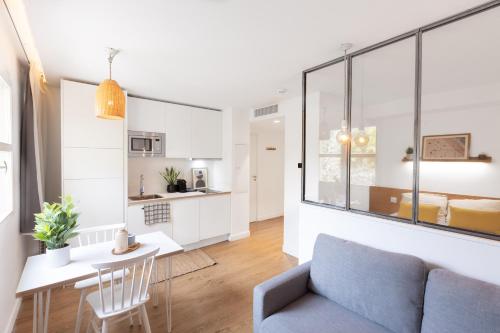 a living room and kitchen with a couch and a table at Les appartements de Montpellier in Montpellier