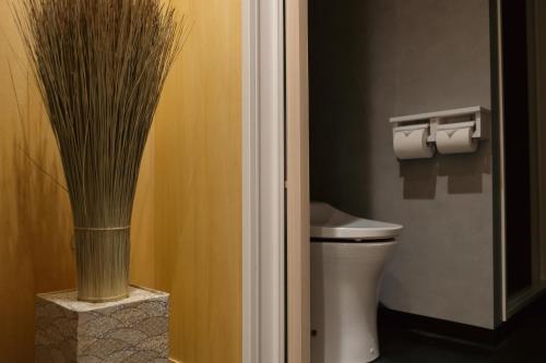 a bathroom with a toilet and a vase at 万雷ホテル in Tokyo