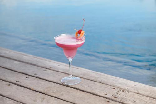 a drink sitting on a wooden table next to the water at Seven Villa Hotel & Spa in Johannesburg