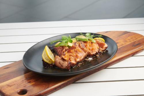 a black plate of food on a wooden cutting board at Seven Villa Hotel & Spa in Johannesburg