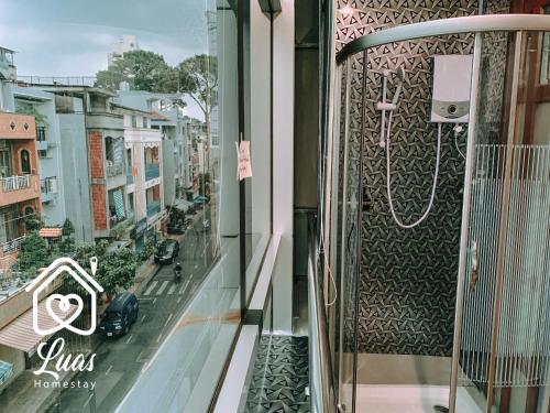 胡志明市的住宿－Luas Cosy Home - The Cosy Chinatown Hideaway，阳台享有酒店的景致,配有淋浴。