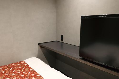 a flat screen tv sitting on a counter in a room at 万雷ホテル in Tokyo