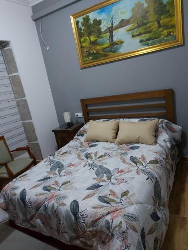 a bedroom with a bed with a painting on the wall at Sailor House in Cambados