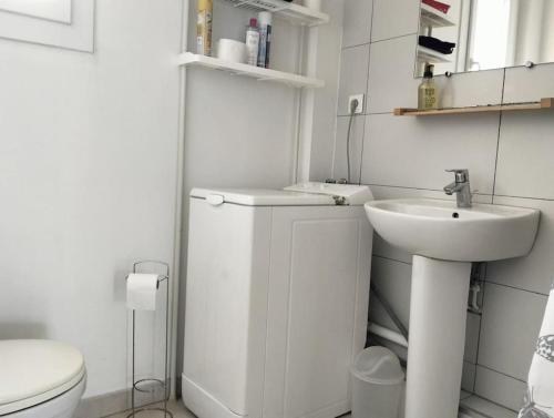 une salle de bain blanche avec un lavabo et des toilettes dans l'établissement Grand appartement T2 sur la Presqu’île de GIENS, à Hyères