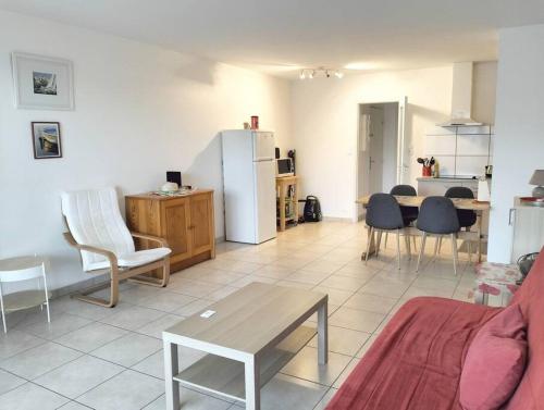 un salon avec une table et des chaises et une cuisine dans l'établissement Grand appartement T2 sur la Presqu’île de GIENS, à Hyères