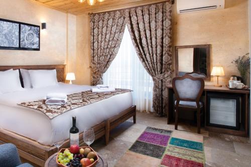 a hotel room with a bed with a bowl of fruit on it at Cappadocia Pyramid Stone House in Uchisar