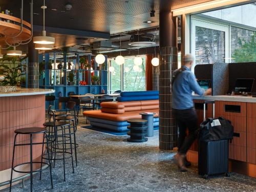 a man standing at a bar in a restaurant at TRIBE Baden-Baden in Baden-Baden