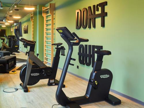 a gym with treadmills and ellipticals in a room at TRIBE Baden-Baden in Baden-Baden