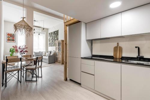 a kitchen and dining room with white cabinets and a table at Charming apartment central Madrid in Madrid