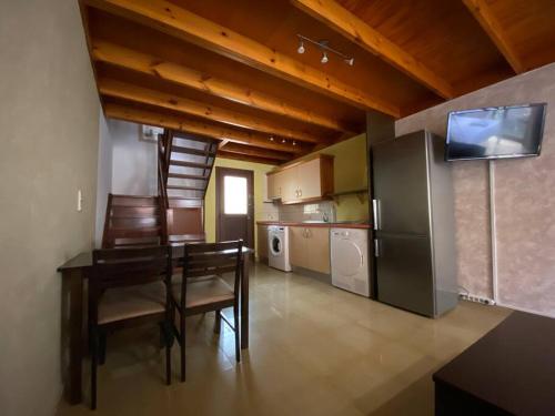 a kitchen with a dining table and a refrigerator at El Olivar Paraíso Playa in Parque Holandes