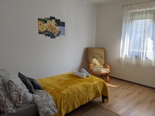 1 dormitorio con 1 cama y 1 silla junto a una ventana en kuća za odmor Dolno en Sisak