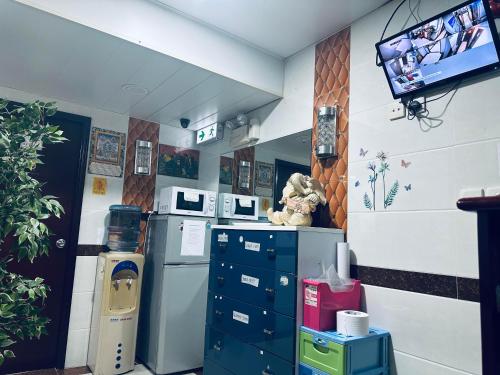 uma cozinha com uma televisão na parede em KATHMANDU GUEST HOUSE em Hong Kong
