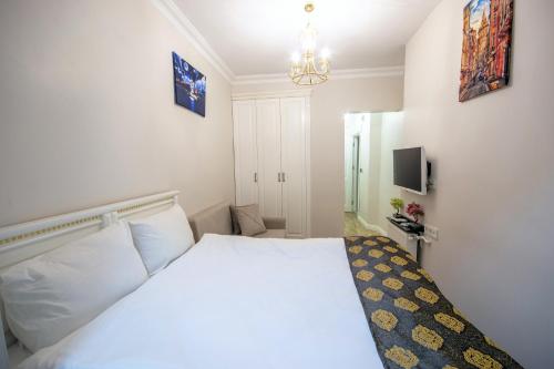 sypialnia z białym łóżkiem i żyrandolem w obiekcie IQ Hotel Beyoğlu w Stambule