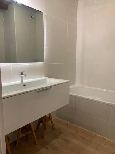 une salle de bain avec un lavabo, un miroir et une baignoire dans l'établissement Studio pied des pistes - Carlines, à Uvernet