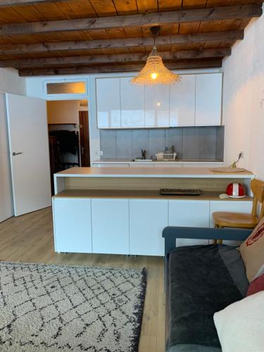 une cuisine avec des armoires blanches et un meuble lumineux dans l'établissement Studio pied des pistes - Carlines, à Uvernet