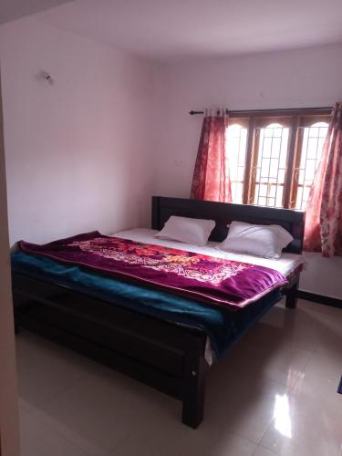 Cama grande en habitación con avertisementatronatronatron en Sai Trishuul home stay, en Ooty