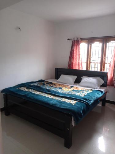 a bed sitting in a room with a window at Sai Trishuul home stay in Ooty