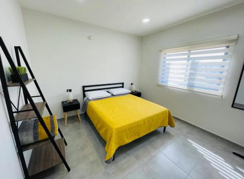 um quarto com uma cama amarela e uma escada em La Ventana Apartments Torote #5 em La Ventana