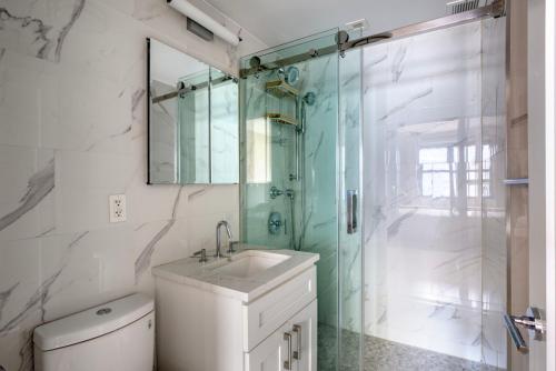 uma casa de banho com um chuveiro, um lavatório e um WC. em UES 1br w gym doorman walk to central park NYC-1332 em Nova York