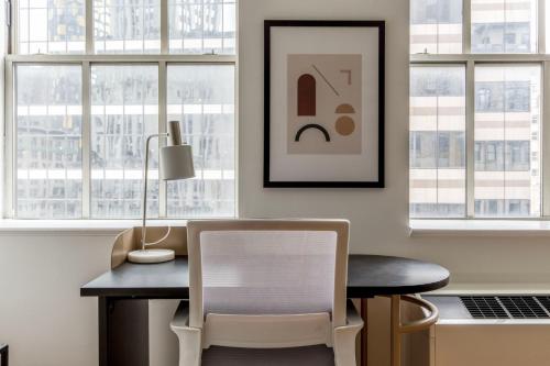 a room with a table and a chair and windows at FiDi 1br w 3-story gym doorman game room NYC-1341 in New York