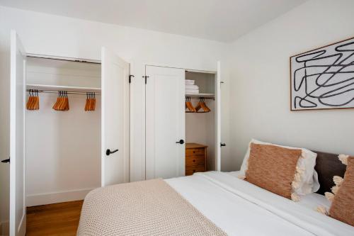 um quarto branco com uma cama e um closet em FiDi jr 1br w bar lounge gym nr wall street NYC-1345 em Nova York