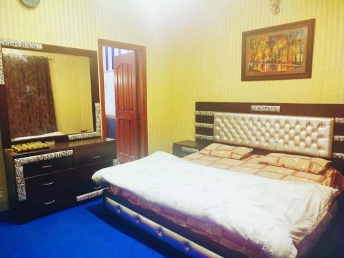 a bedroom with a bed and a large mirror at Rashk e Qamar in Murree