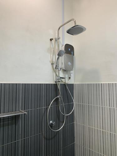 a shower in a bathroom with a shower head at A home with private pool, Kebun Kecil in Tangga Batu
