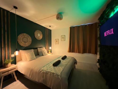 a bedroom with a bed with a sign on the wall at ~ Le Jungle ~ Petit cocon au porte du Futuroscope in Chasseneuil-du-Poitou