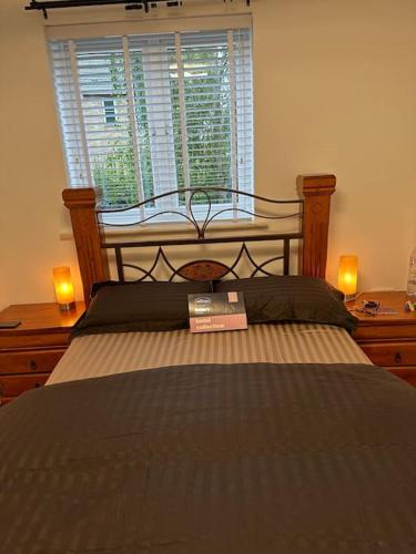 a bedroom with a bed with a window and two lamps at 2 Bedrooms Luxurious Apartment in Luton in Luton