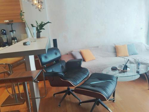 ein Wohnzimmer mit einem Sofa, einem Tisch und Stühlen in der Unterkunft Aris Apt in Karystos