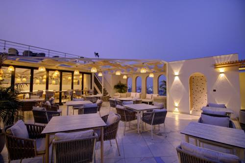 a restaurant with tables and chairs on a patio at Cygnett Collection K K Hotel in Faizābād