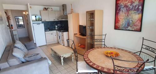 une cuisine et un salon avec une table et un canapé dans l'établissement 096 Roches Noiires A26, au Cap d'Agde