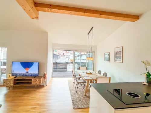 sala de estar con TV y mesa en Sunset Club - Nesselwang Chalets Nr 1, en Nesselwang