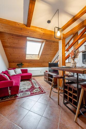 a living room with a red couch and a table at Apartmán Mezonet na Námestí Košice in Košice