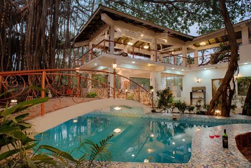 a house with a swimming pool and a bridge at The Singing Tree in Old Goa