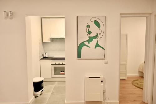 a white kitchen with a painting on the wall at For You Rentals Encantadora Vivienda de 3 Dormitorios descubre el Confort que Estabas Buscando DSA434D in Madrid