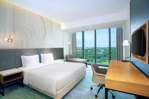 a hotel room with a bed and a desk and a computer at Radisson Golf & Convention Center Batam in Batam Center