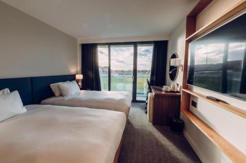 a hotel room with two beds and a flat screen tv at Hilton Garden Inn Manchester Emirates Old Trafford in Manchester