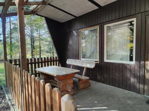 einem Holztisch und einer Bank auf der Veranda einer Hütte in der Unterkunft Kleine Freiheit Nummer 4 in Reichendorf