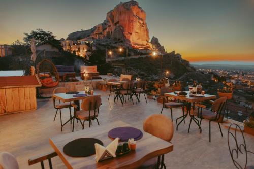 a restaurant with tables and chairs and a mountain at Tale Cave İnn in Ürgüp