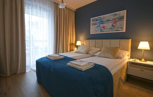 a bedroom with a large bed with a blue blanket at IRS ROYAL APARTMENTS Apartamenty IRS Nadmorski Dwór 2 in Gdańsk