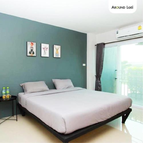 a bedroom with a large bed with a blue wall at Around Loei in Loei