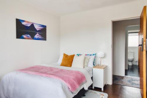 a white bedroom with a bed and a mirror at Sweet Home between CBD and University in Hamilton
