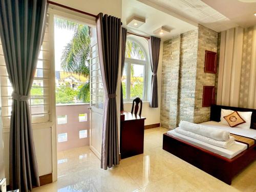 a bedroom with a bed and a large window at Phuc Hung Hotel in Rạch Giá