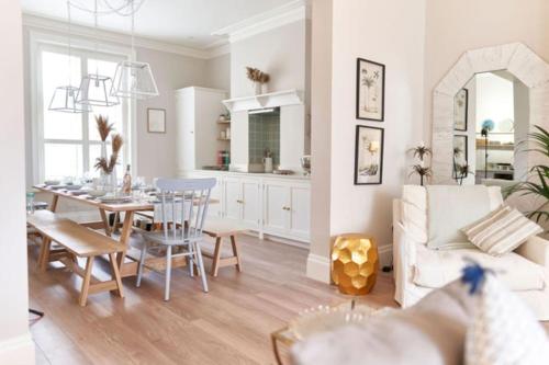 uma cozinha e sala de estar com uma mesa e um sofá em Cute Beach House - 4 mins walk em Bournemouth
