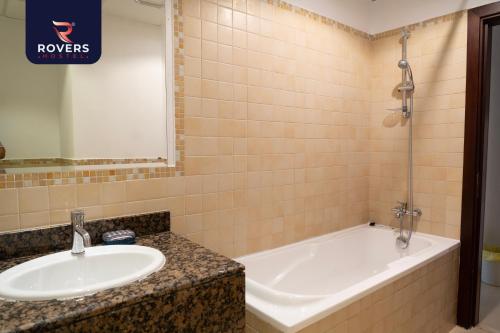 uma casa de banho com um lavatório e uma banheira em Rovers Hostel Dubai em Dubai