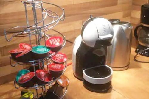 a stand with a coffee maker and some cupcakes at "L'oranger" Arles Terrasse in Arles