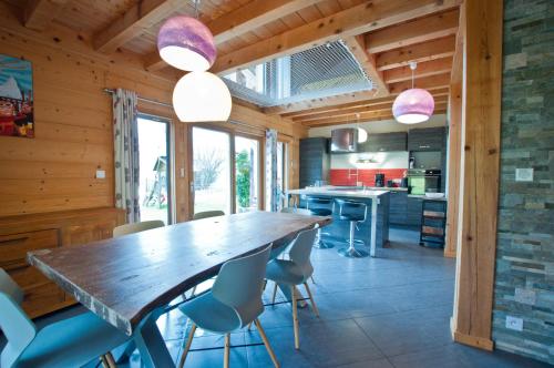 une cuisine avec une grande table et des chaises en bois dans l'établissement Chalet La Merlerie, à Morzine