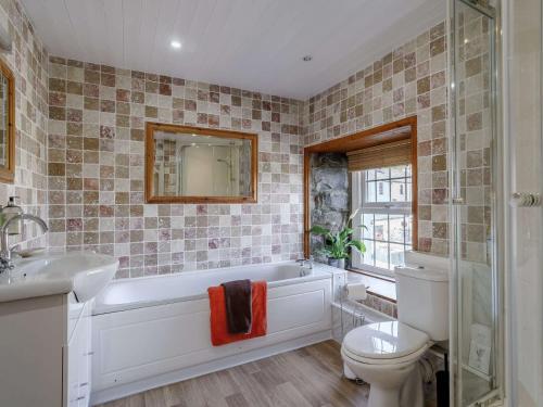 a bathroom with a tub and a toilet and a sink at 4 Bed in New Quay 78589 in New Quay